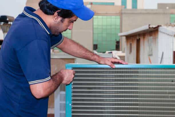 a Professional electrician Repairing an air conditioner compressor