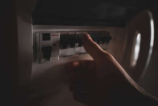 Male hand using fuse board relay.